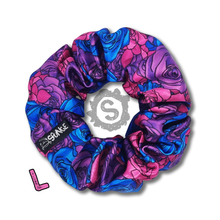 Load image into Gallery viewer, A large colourful scrunchie. A rose pattern in the colours of the Bisexual pride flag. Blue, pink and purple. Approximately 12cm in Diameter.
