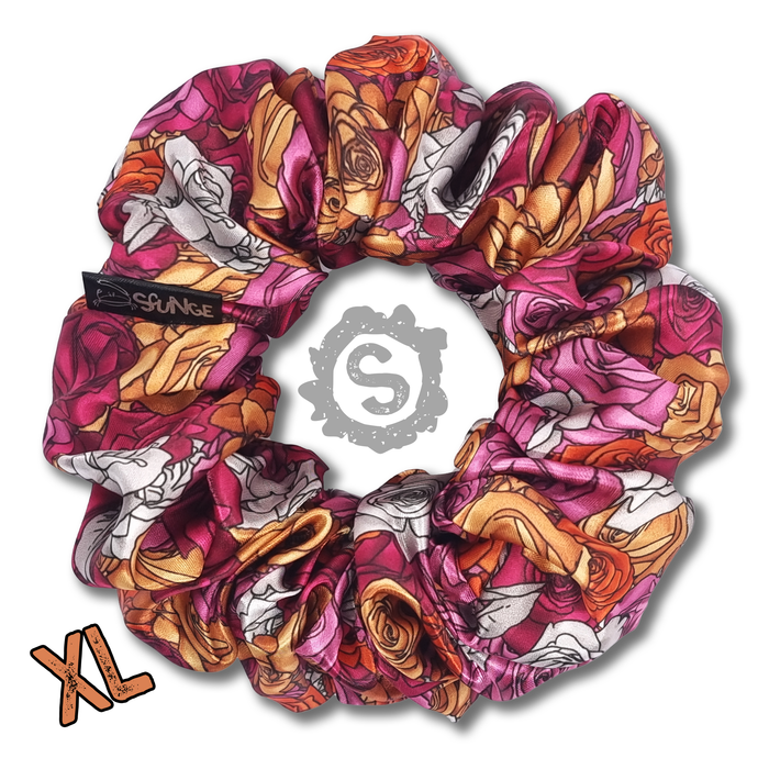 An extra large colourful scrunchie. A rose pattern in the colours of the Lesbian pride flag. White, orange and pink. Approximately 15cm in Diameter.