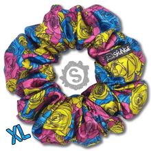 Load image into Gallery viewer, An extra large colourful scrunchie. A rose pattern in the colours of the Pansexual pride flag. Blue, pink and yellow. Approximately 15cm in Diameter.
