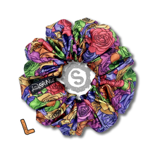 Load image into Gallery viewer, A large colourful scrunchie. A rose pattern in the colours of the pride flag. Red, orange, yellow, blue, green and purple. Approximately 12cm in Diameter.
