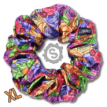 Load image into Gallery viewer, An extra large colourful scrunchie. A rose pattern in the colours of the pride flag. Red, orange, yellow, blue, green and purple. Approximately 15cm in Diameter.
