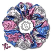 Load image into Gallery viewer, An extra large colourful scrunchie. A rose pattern in the colours of the trans pride flag. Blue, white and pink. Approximately 15cm in Diameter.
