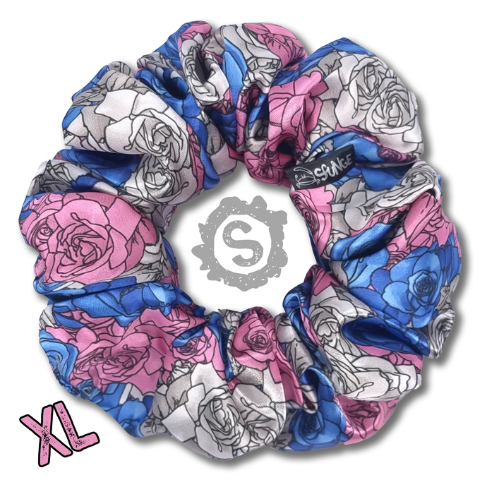 An extra large colourful scrunchie. A rose pattern in the colours of the trans pride flag. Blue, white and pink. Approximately 15cm in Diameter.