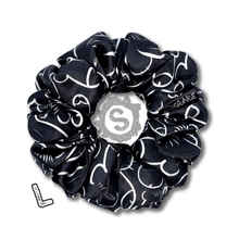 Load image into Gallery viewer, A large black scrunchie, black satin covered in a myriad of white penises. Approximately 12cm in Diameter.
