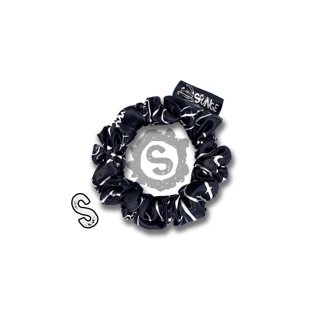 A small black scrunchie, black satin covered in a myriad of white penises. Approximately 8cm in Diameter.