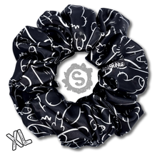 Load image into Gallery viewer, An extra large black scrunchie, black satin covered in a myriad of white penises. Approximately 15cm in Diameter.
