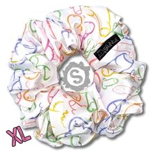 Load image into Gallery viewer, A small white scrunchie, white satin covered in a myriad of colourful penises. Approximately 15cm in Diameter.
